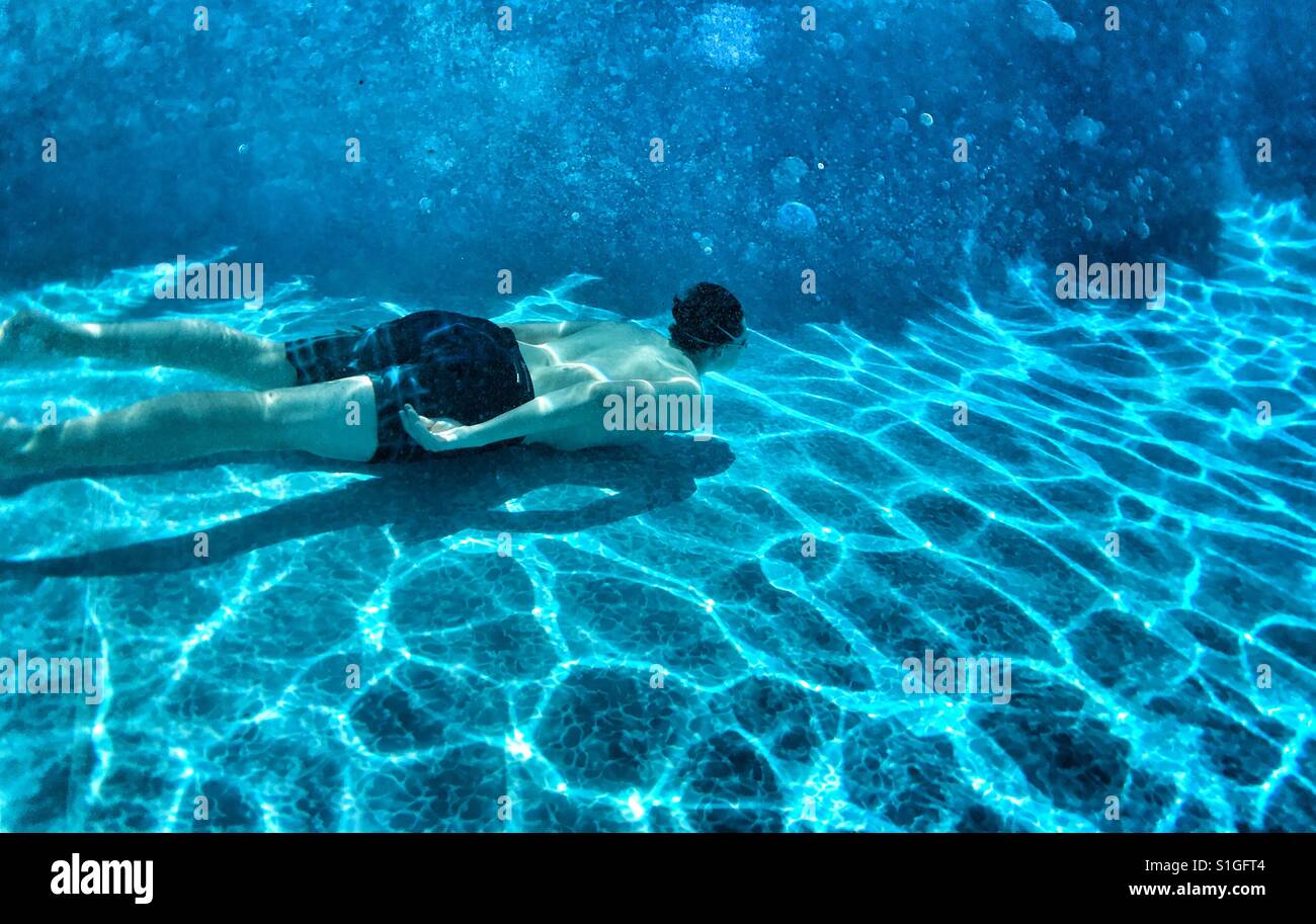 Young man swimming underwater in an outdoor swimming pool Stock Photo ...
