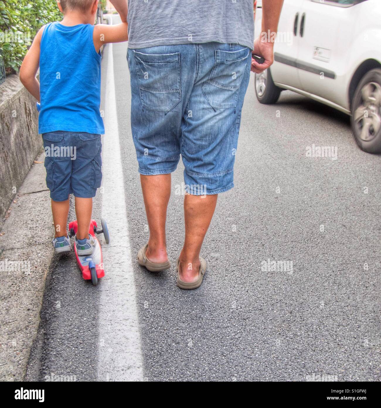 Father taking care of the small son in the street traffic - Smartphone Captured Stock Image