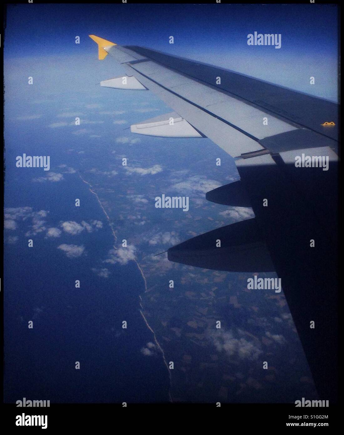 The view from seat 19A of the Northern French coastline from a Monarch Airways flight from Leeds Bradford Airport, UK. - Smartphone Captured Stock Image
