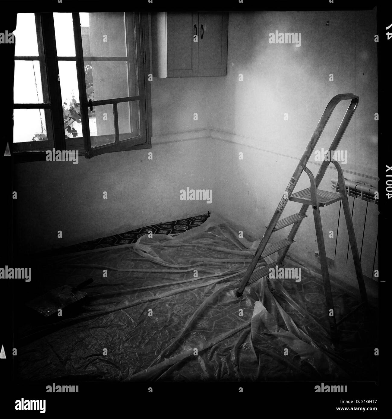 Step ladder and dust sheets in an empty room ready for painting and decorating. - Smartphone Captured Stock Image