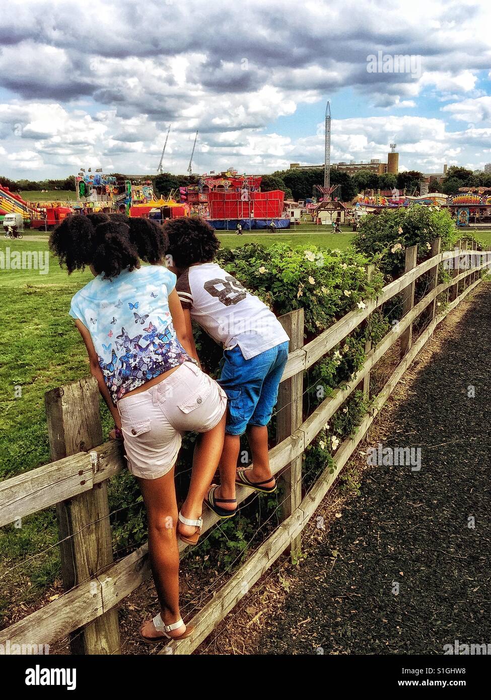 Children watching a funfair. - Smartphone Captured Stock Image