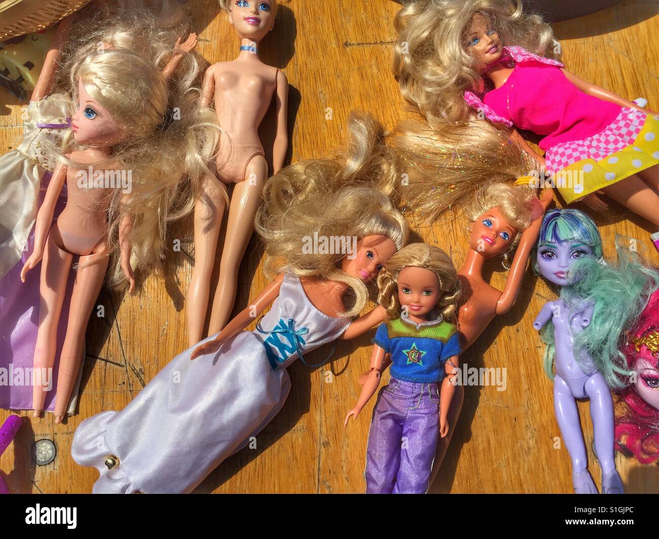 Barbie dolls and various children's toy dolls are seen for sale at a car boot sale in Sussex in England Stock Photo