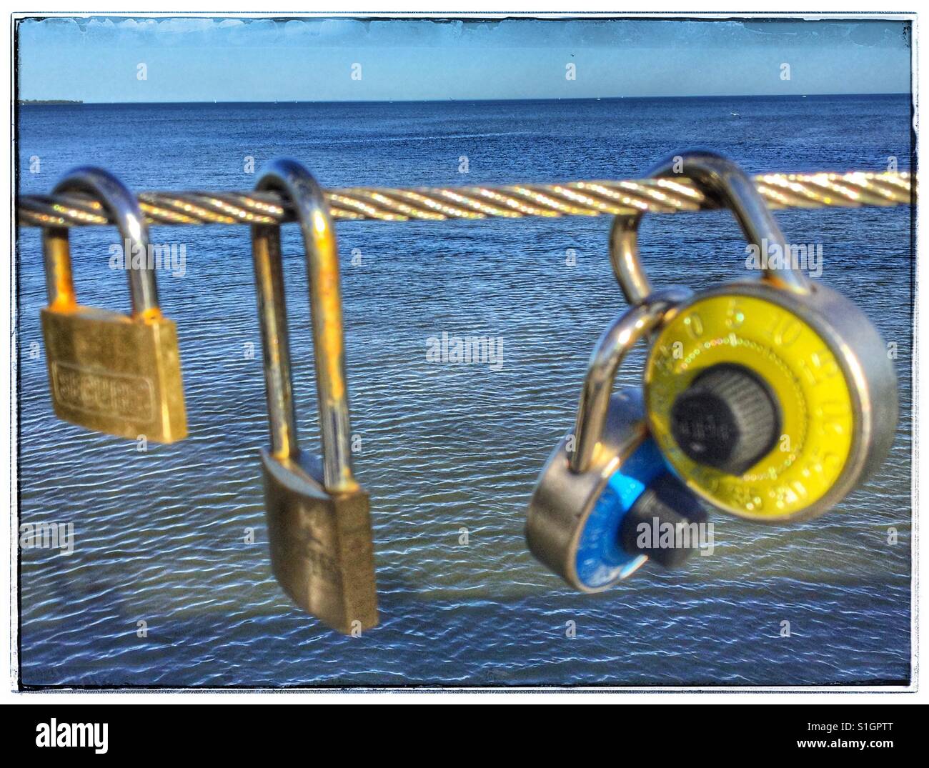 Four love locks hanging on the Humber Bay bridge in Toronto, Ontario. - Smartphone Captured Stock Image