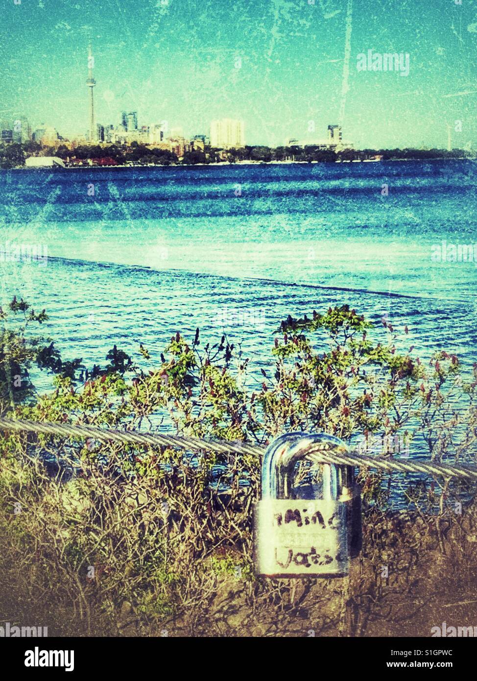 Toronto skyline and waterfront as a backdrop for a love lock hanging on the Humber Bay bridge in Toronto , Ontario. Stock Photo