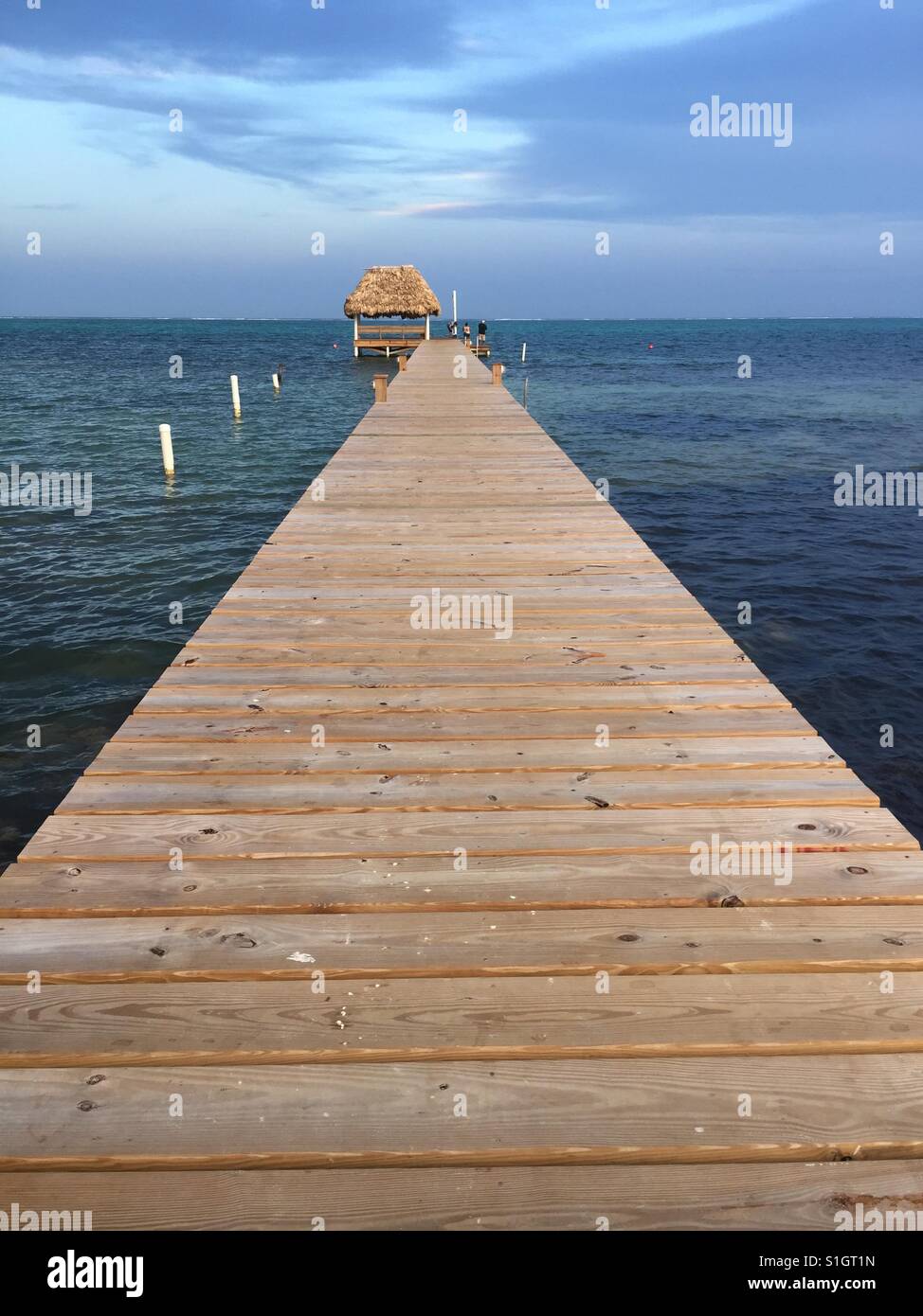 Pier and thatch palapa over Caribbean Sea. Stock Photo