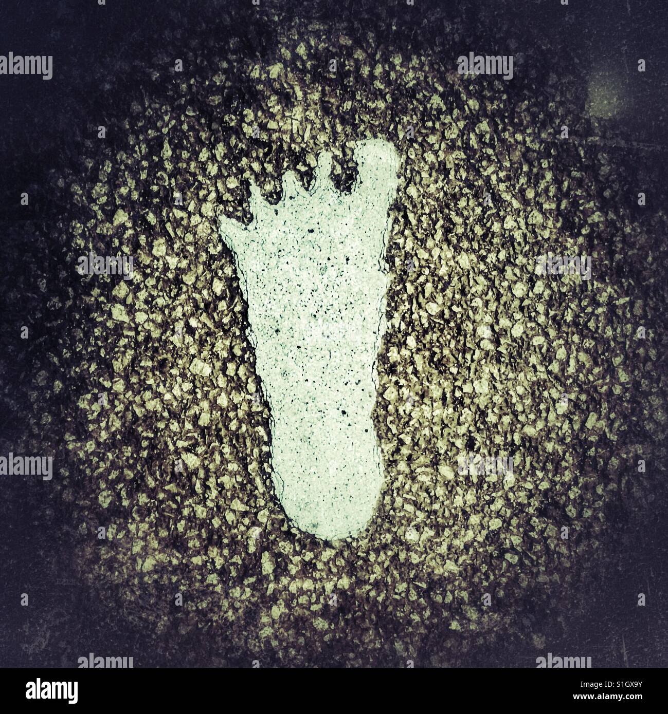 Fading painted footprint on a pavement - Smartphone Captured Stock Image