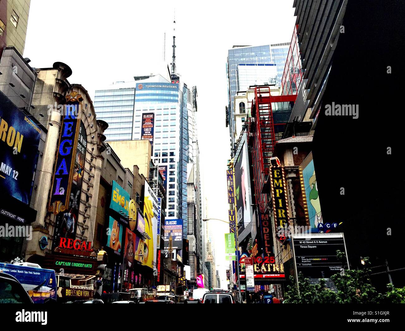 Time Square, 42nd Street, flowing east, black sign identifies location, Crossroads of the World, Theaters, Corporations, Office buildings,Landmarks,Subways, traffic, tour buses, yes even a green bush Stock Photo