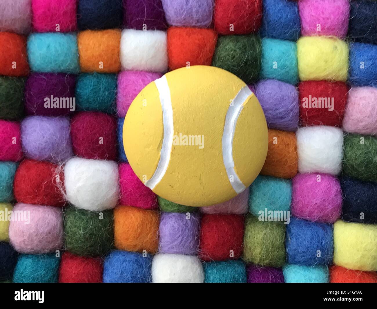 Stone tennis ball over multicolored elements Stock Photo