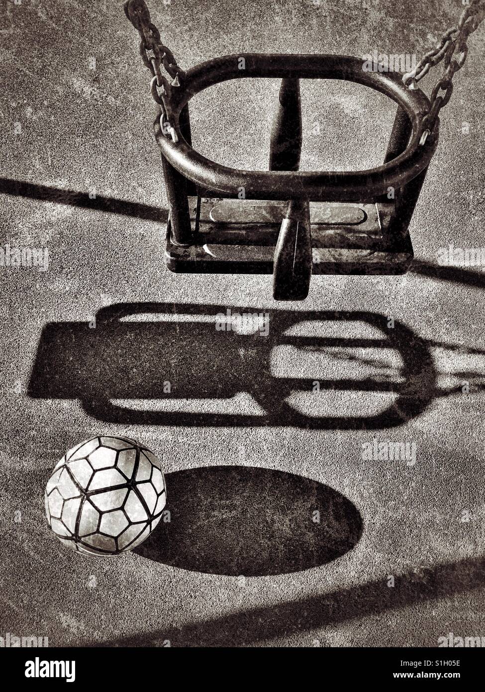 Shadows of a swing and football in a children's playground area. Nobody is present. Where are the children? An image with multiple uses. Photo © COLIN HOSKINS. - Smartphone Captured Stock Image
