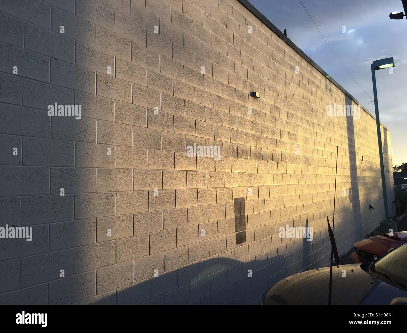 The side of an industrial building during golden hour. Stock Photo
