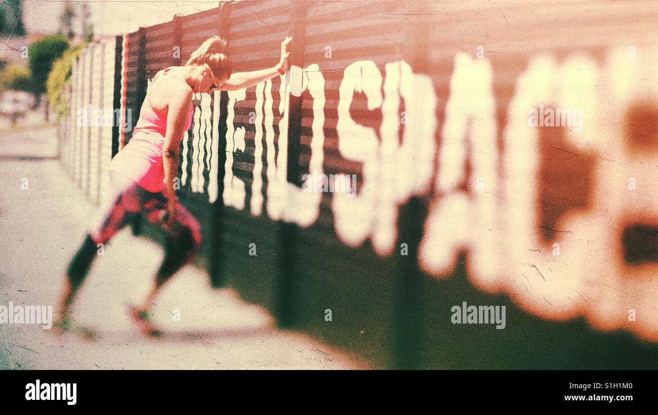 Young tall confident woman stretching in the street after running - Smartphone Captured Stock Image