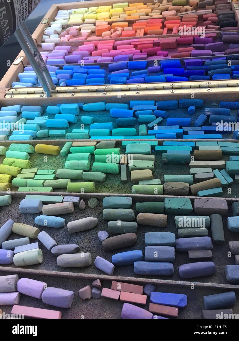 Colorful assortment of pastel chalk in artists easel tray. Many subtle