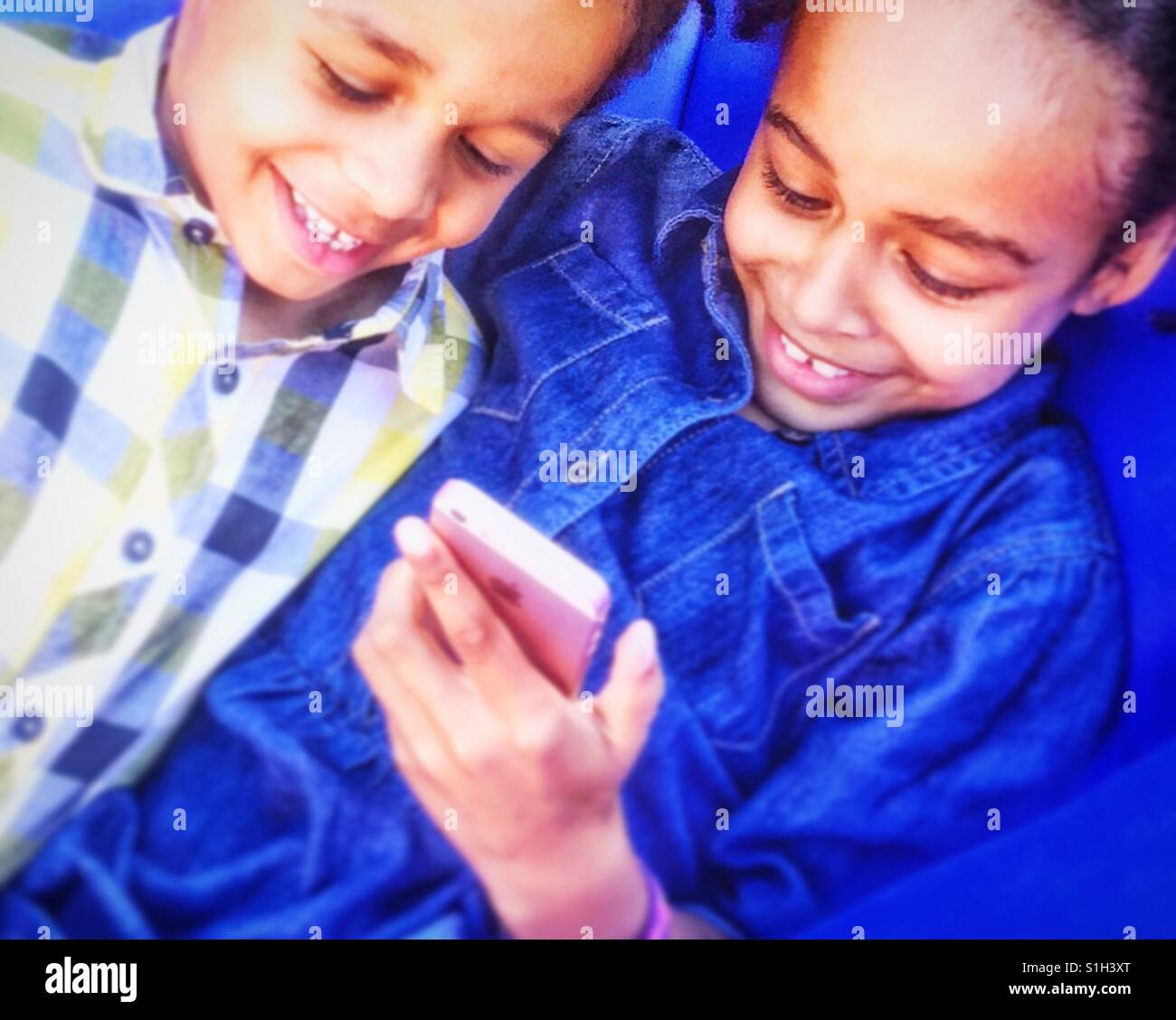 Children enjoying a mobile phone. - Smartphone Captured Stock Image