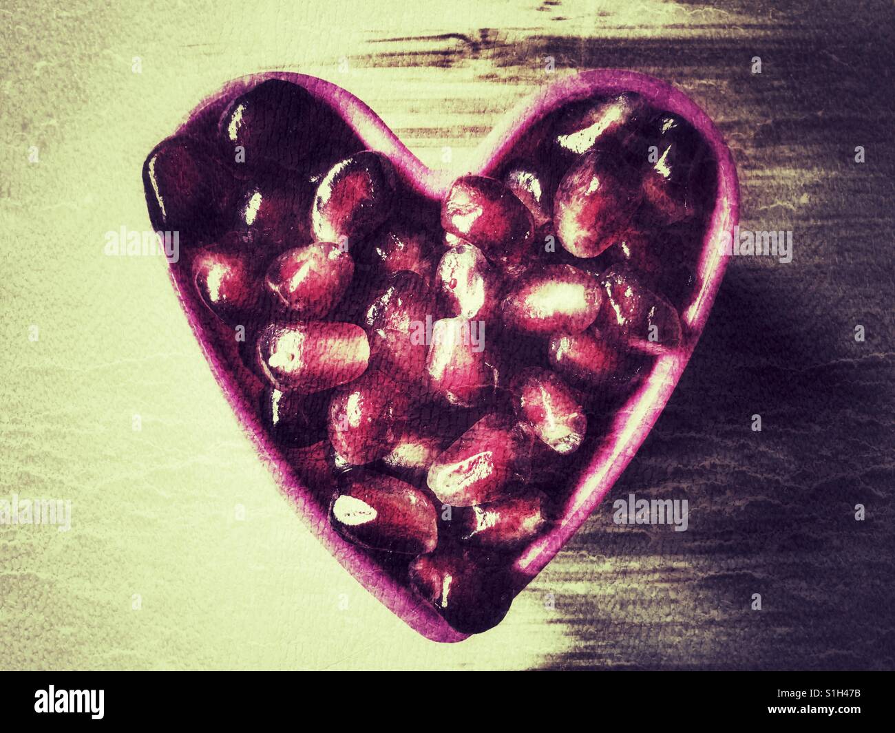 Pomegranate arils (seeds), Punica granatum in a pink heart - Smartphone Captured Stock Image
