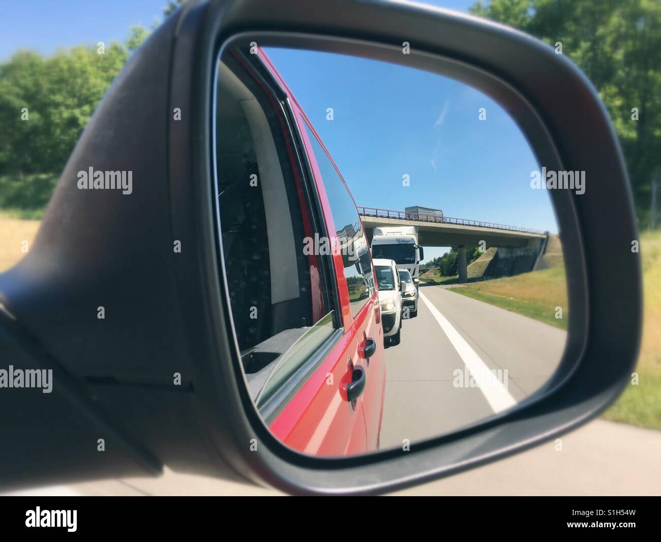 Rear View mirror showing a traffic jam on a German highway - Smartphone Captured Stock Image