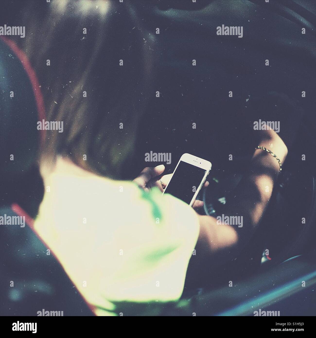 Woman texting on smart phone while driving - Smartphone Captured Stock Image