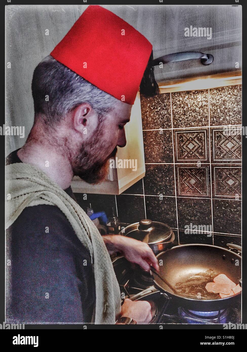 Man in Fez cooking. Stock Photo