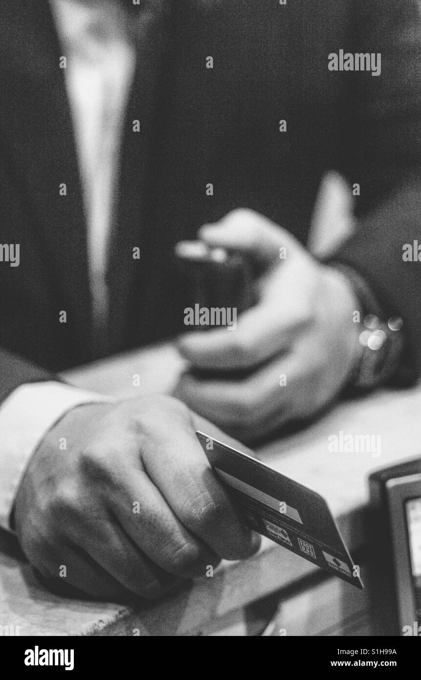 Detail of a man 's hand paying the bill with a credit card - Smartphone Captured Stock Image