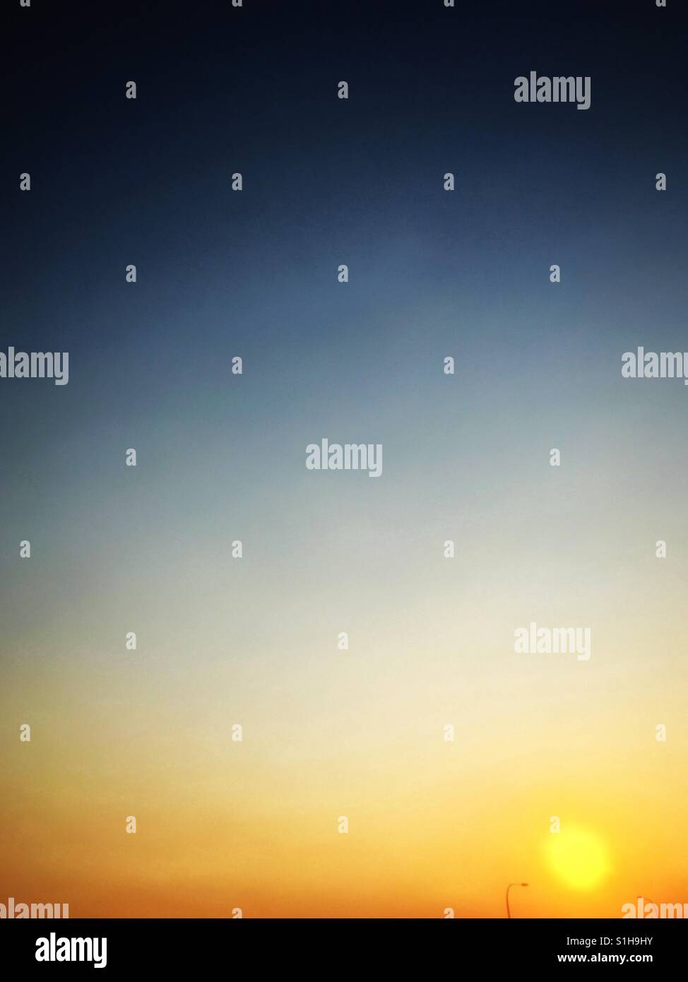 Sunset between two lampposts. - Smartphone Captured Stock Image