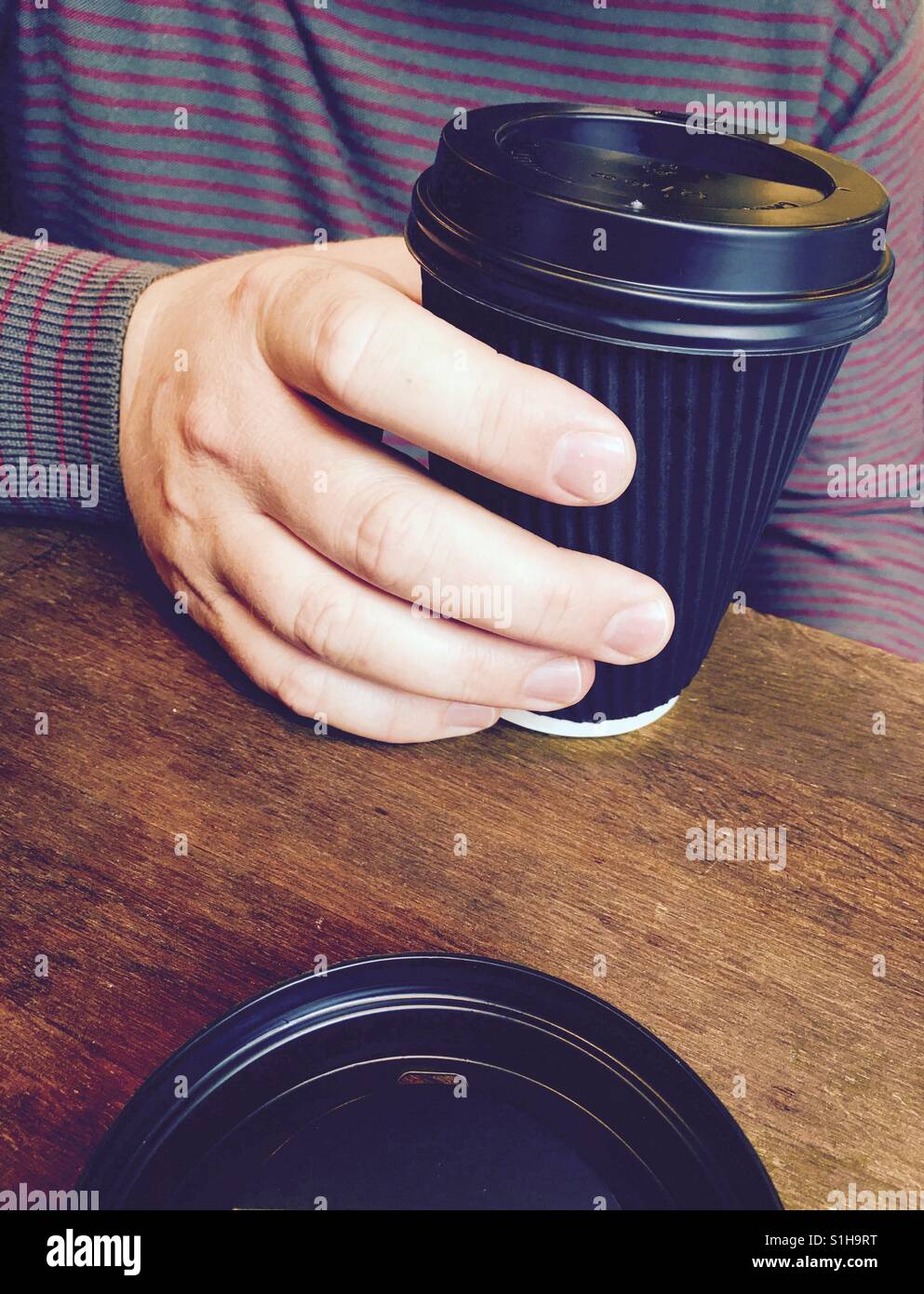 Hand holding. black take away coffee cup - Smartphone Captured Stock Image
