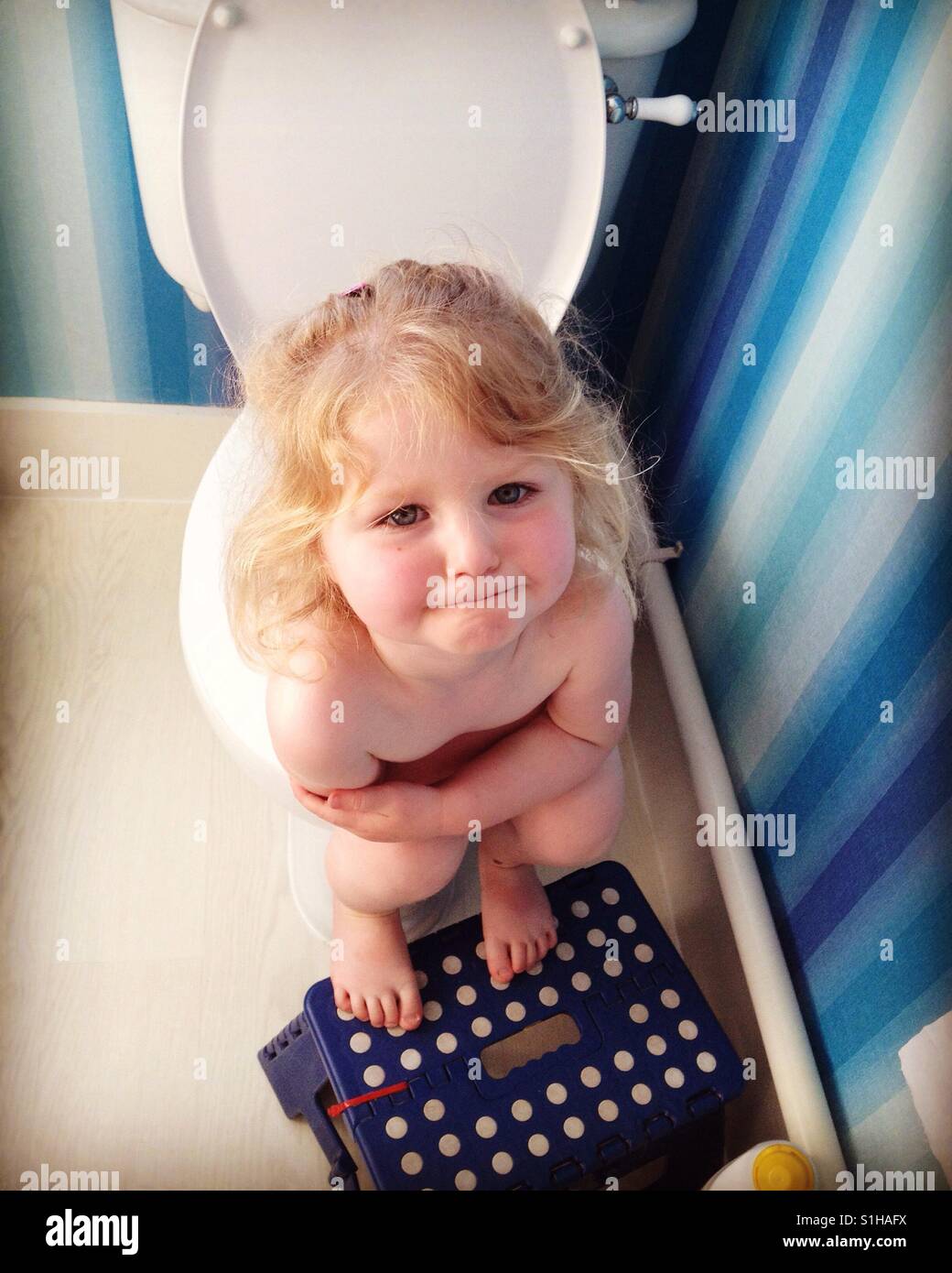Toddler child kid goes to the toilet as part of toilet training. Stock Photo