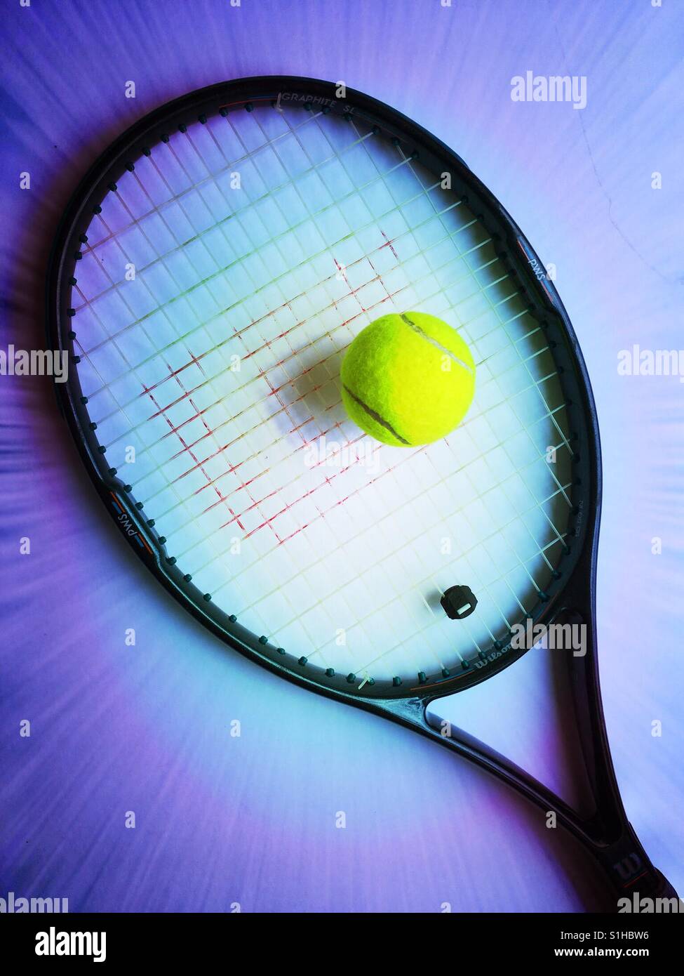 Graphite tennis racket and tennis ball Stock Photo