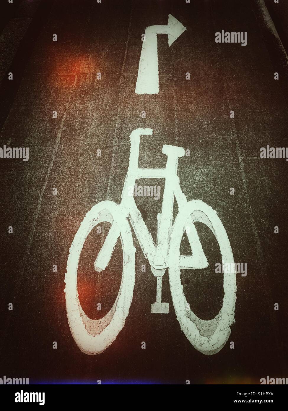 A retro film effect picture depicting a painted image of a bicycle and a turn right arrow sign. As the world becomes more aware of climate change, renewable energy for transportation is encouraged. - Smartphone Captured Stock Image