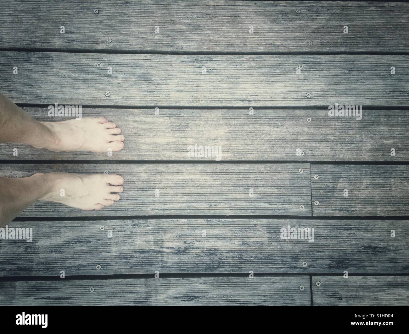Bare foot on a wooden board Stock Photo