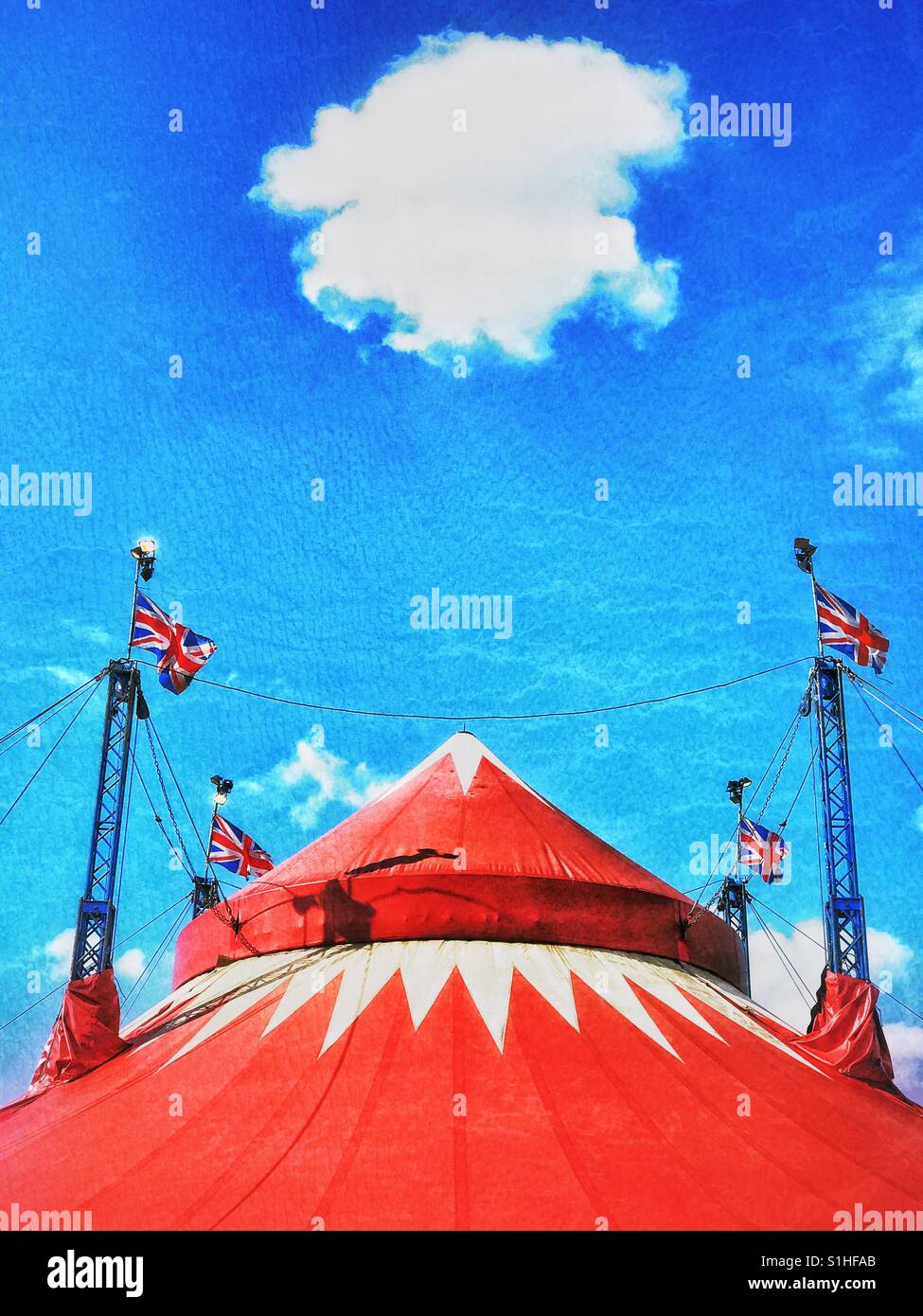 A lone cloud hangs above the top of a large circus tent in England. It's a sunny Summers day. The clowns are ready to perform! Photo Credit - © COLIN HOSKINS. - Smartphone Captured Stock Image