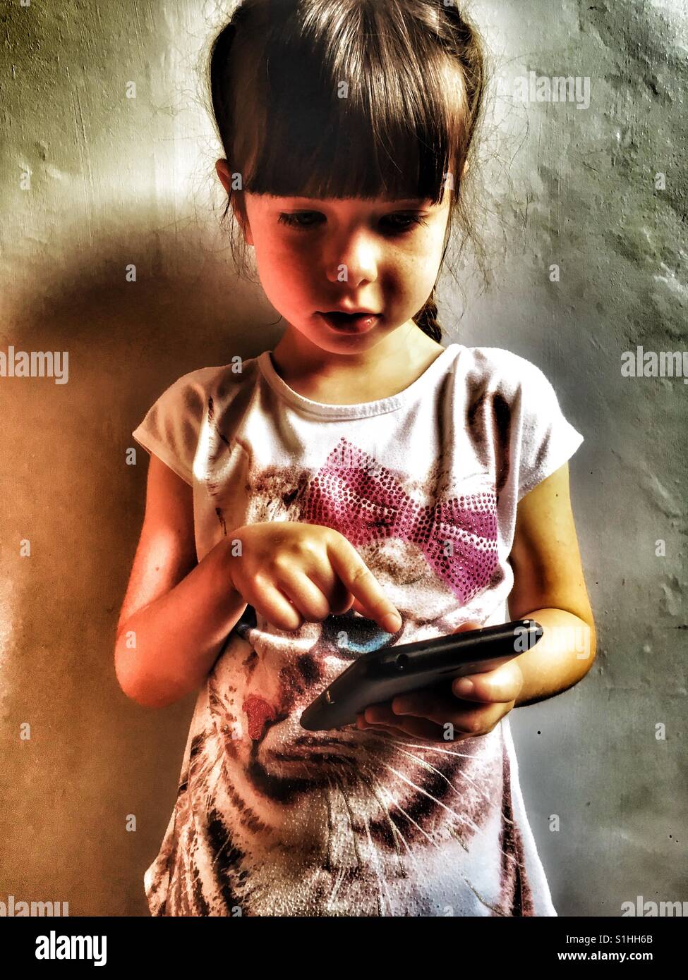5-year old girl using a smartphone - Smartphone Captured Stock Image