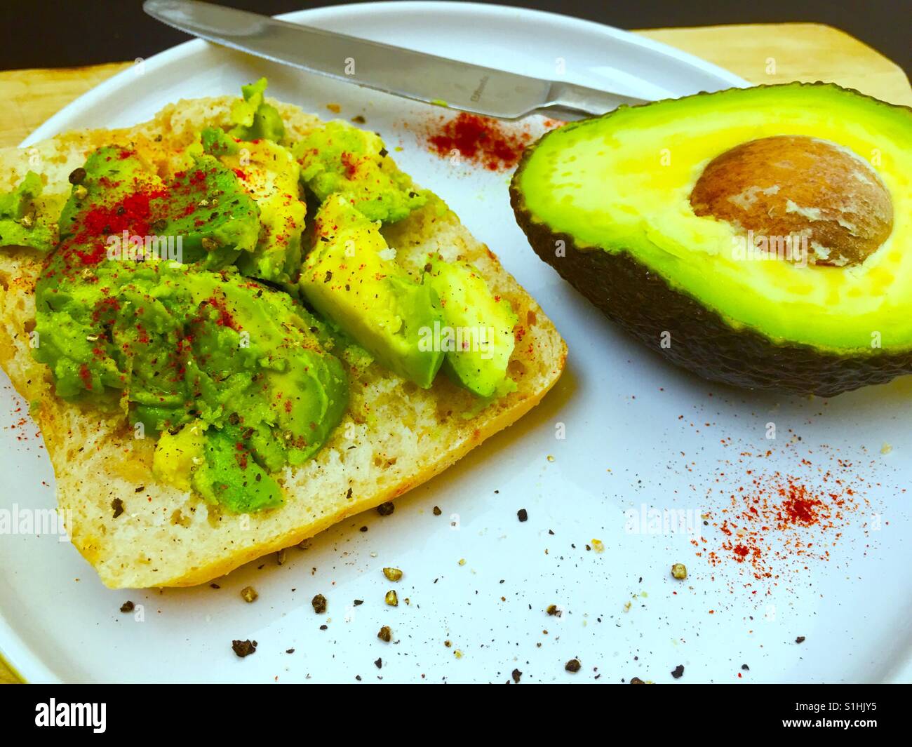 Crashed avocado on white bread with paprika and black pepper - Smartphone Captured Stock Image