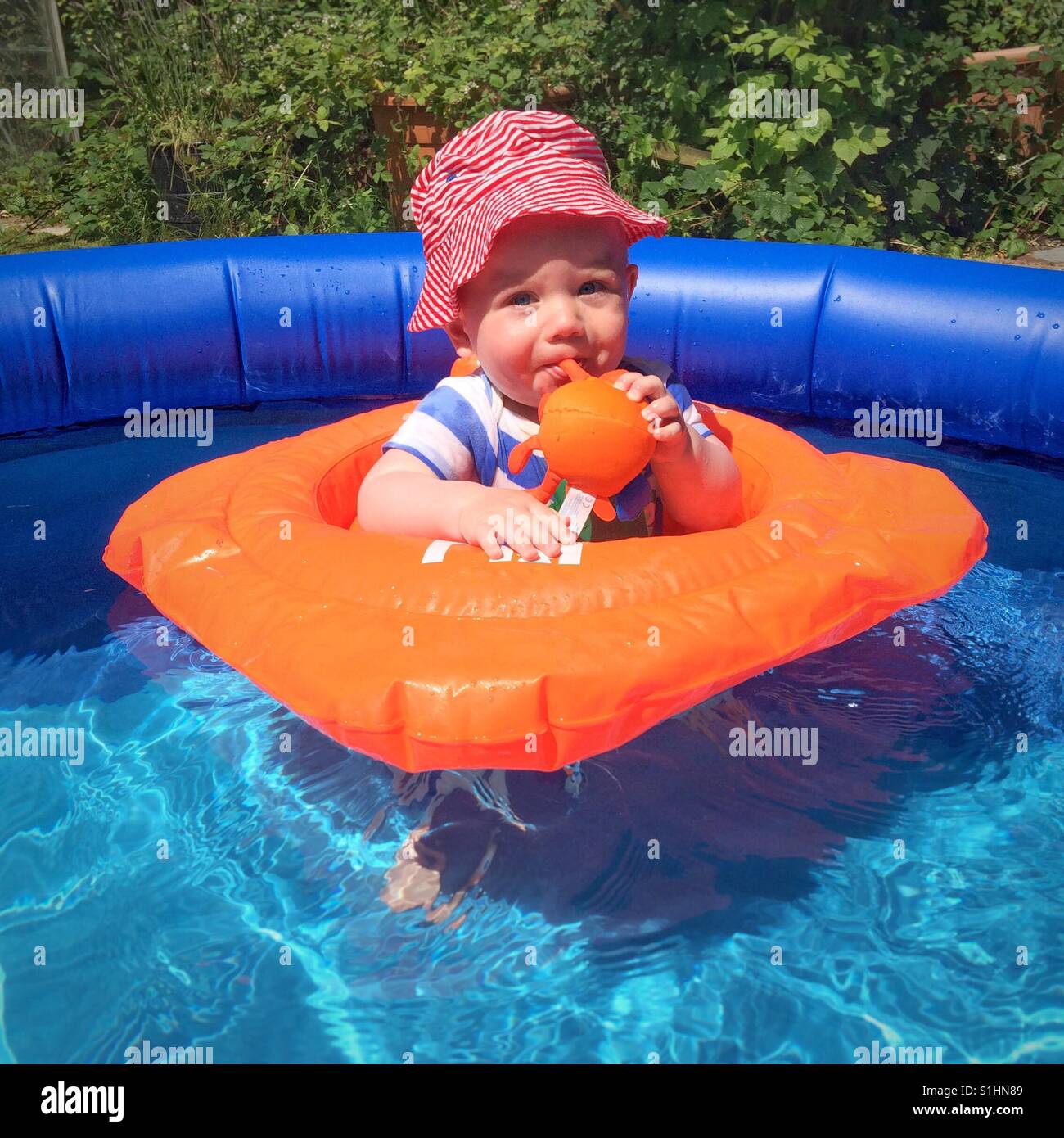 Ten month old baby boy in a paddling pool Stock Photo