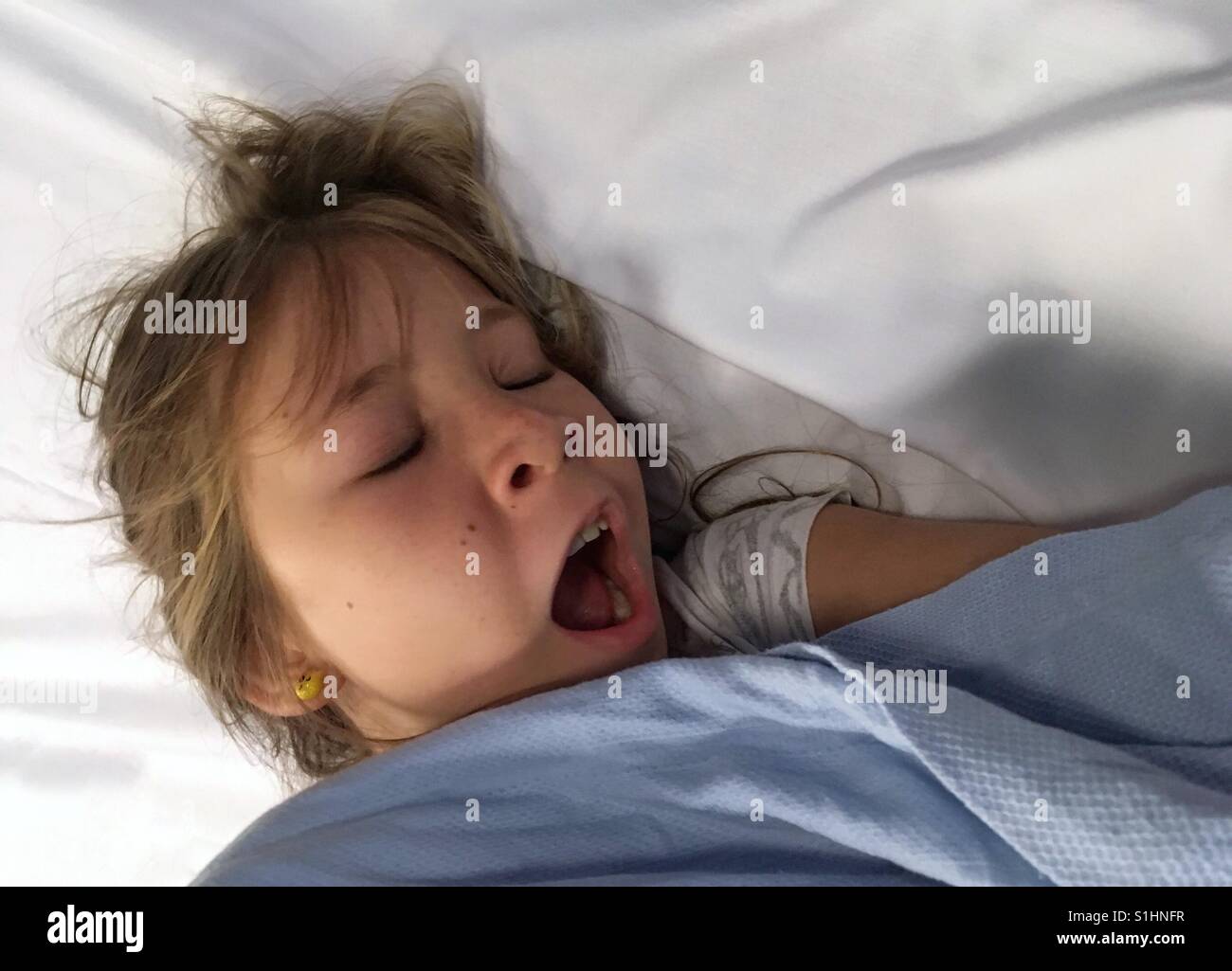 Child yawning in her bed Stock Photo - Alamy