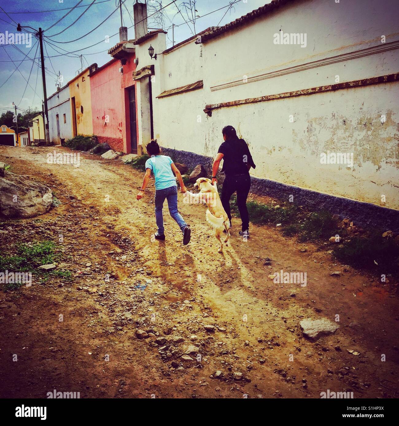 Taking the dog for a walk hand in paw! In San Juan del Obispo near Antigua, Guatemala - Smartphone Captured Stock Image