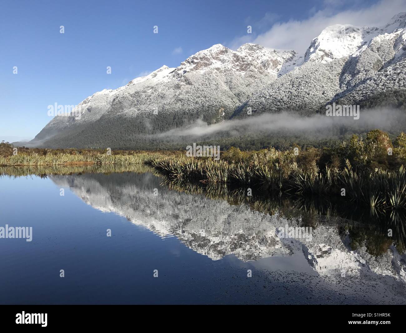New Zealand- mirror lake. Perfect balance of sky, snow mountain and lake. Magnificent view of glaciers Stock Photo