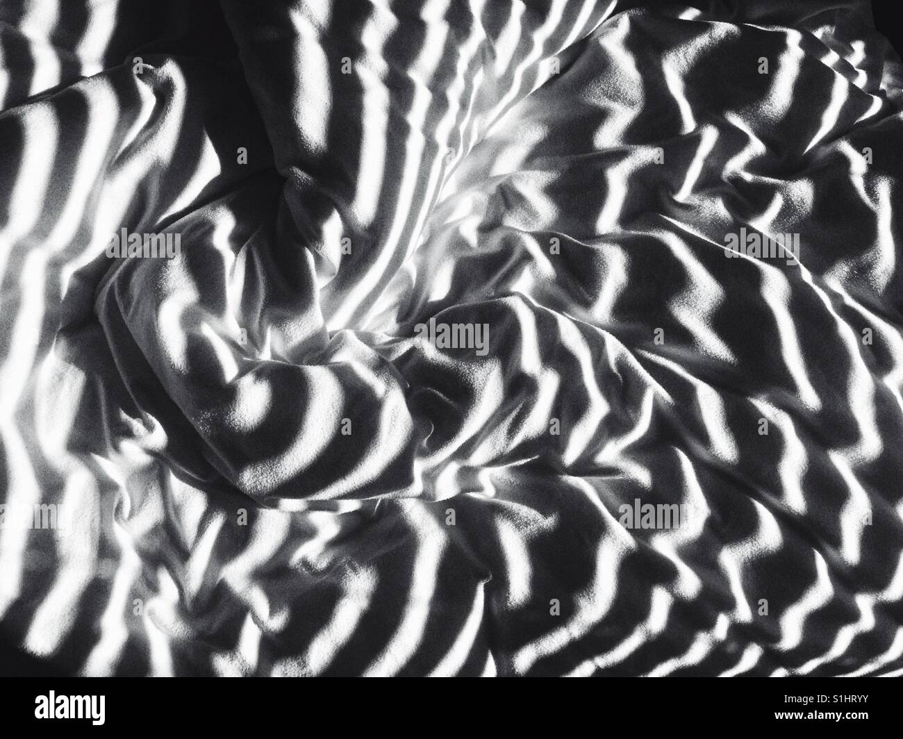 Messy white bedding on lazy sunny summer morning with light through the blinds - Smartphone Captured Stock Image