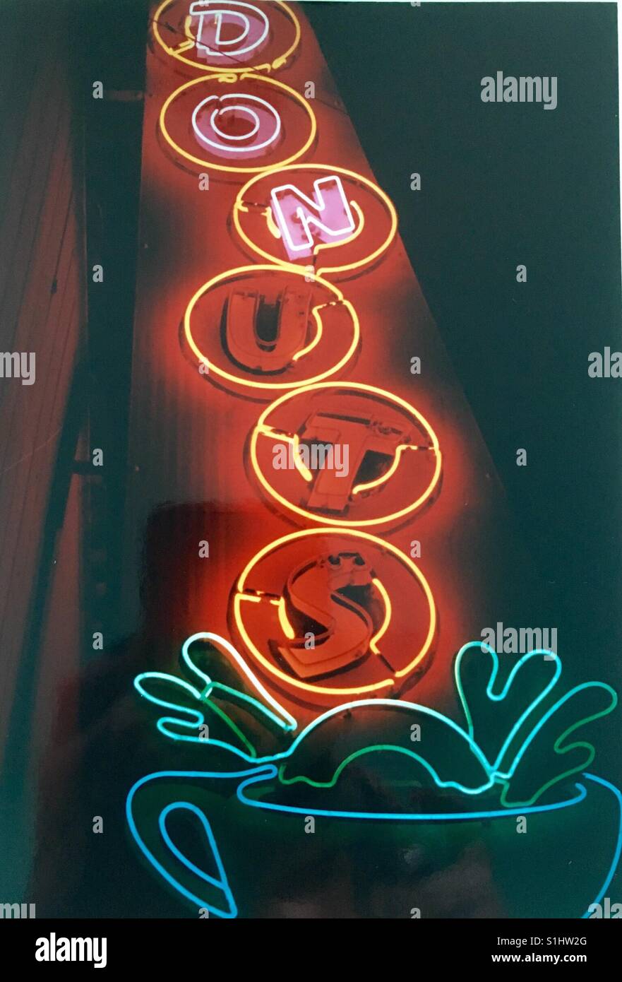 Donuts and Coffee Cup Neon sign in Los Angeles in 1980's donut dunked in coffee cup Stock Photo