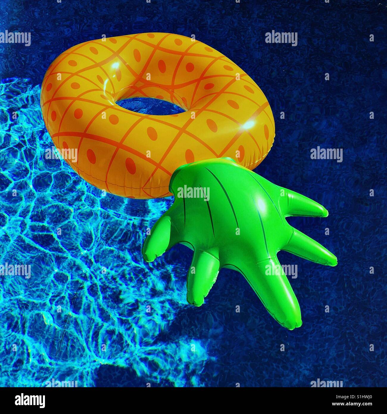Floating pineapple pool toy on a hot sunny day. Square crop Stock Photo ...