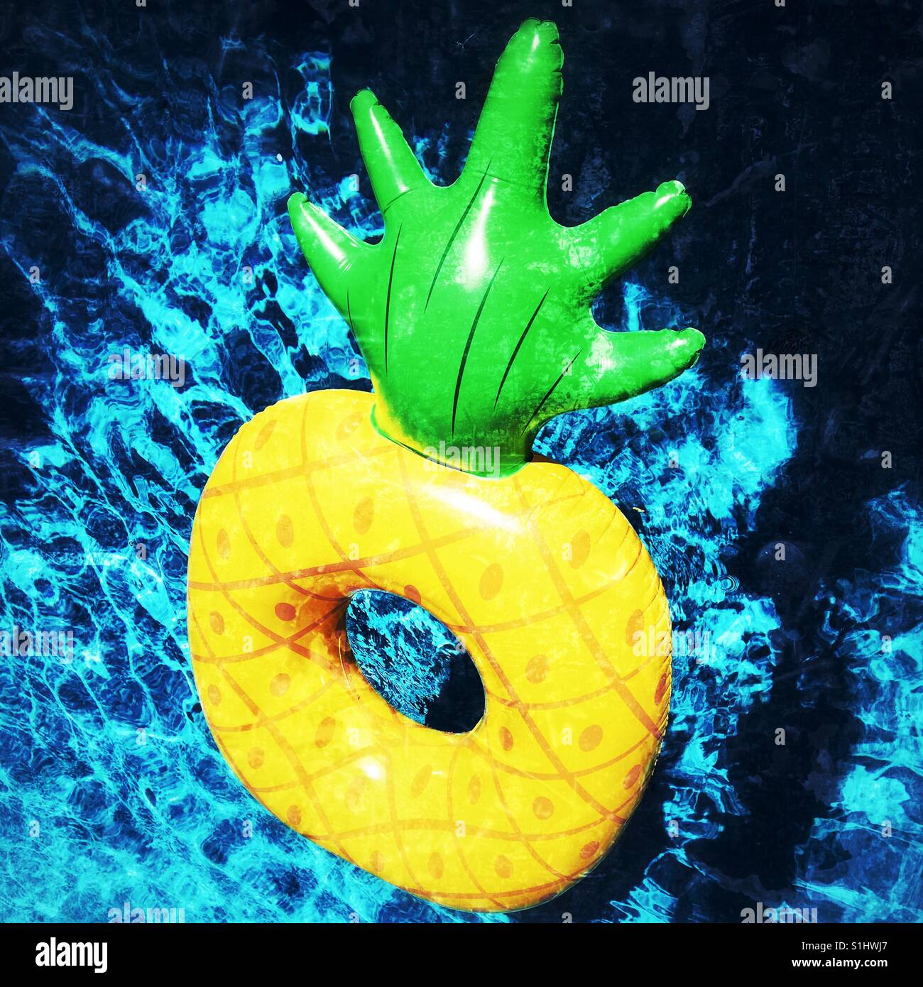 Pineapple pool toy floating on swimming pool water. Square crop. - Smartphone Captured Stock Image