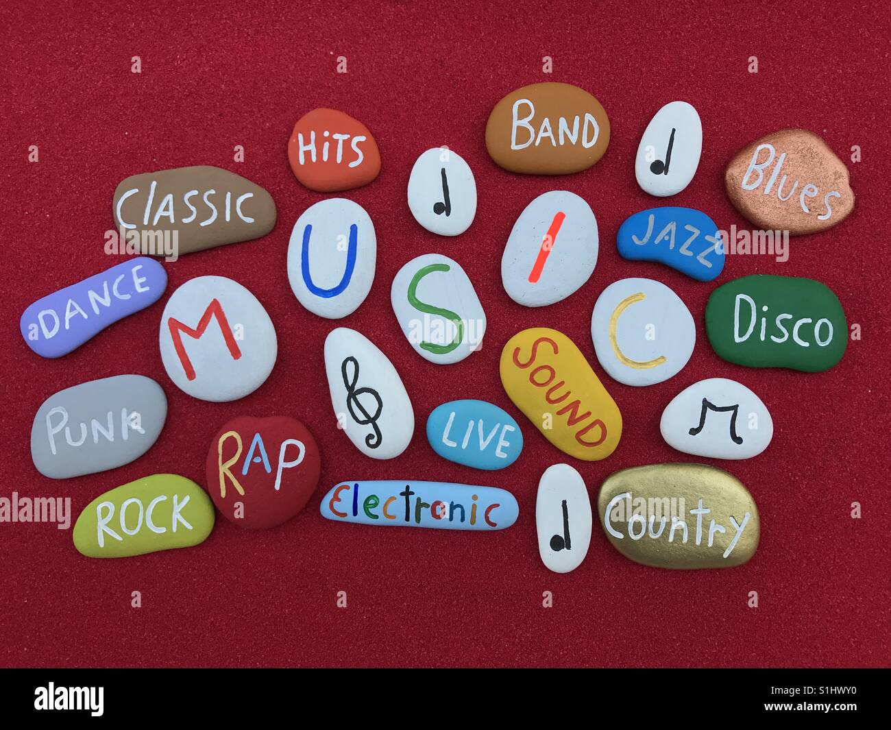 Music cloud with carved and colored stones over red sand - Smartphone Captured Stock Image