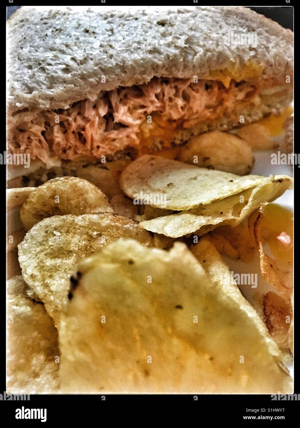Tuna and egg sandwich with chilli sauce and mayo, and crisps Stock