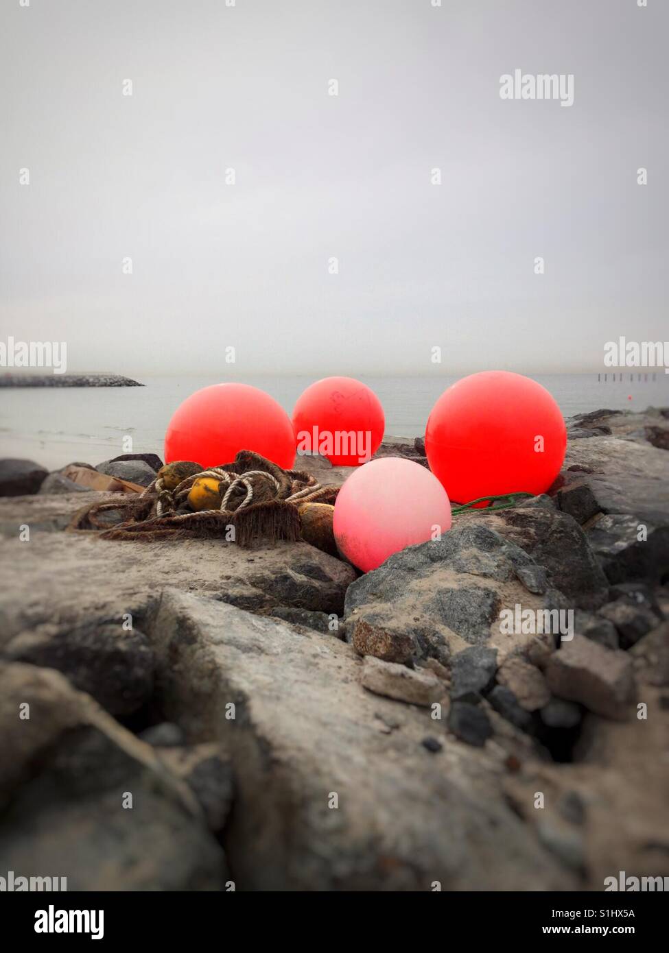 Stranded Buoy Buoys and rope stranded on seawall Stock Photo - Alamy