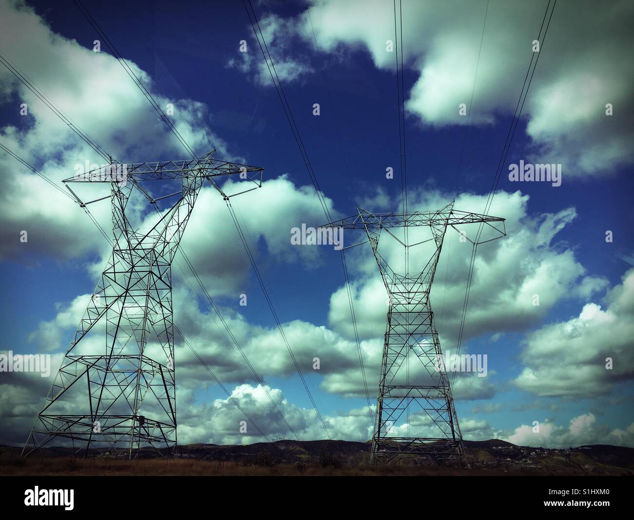 Power cable towers with clouds in a blue sky - Smartphone Captured Stock Image