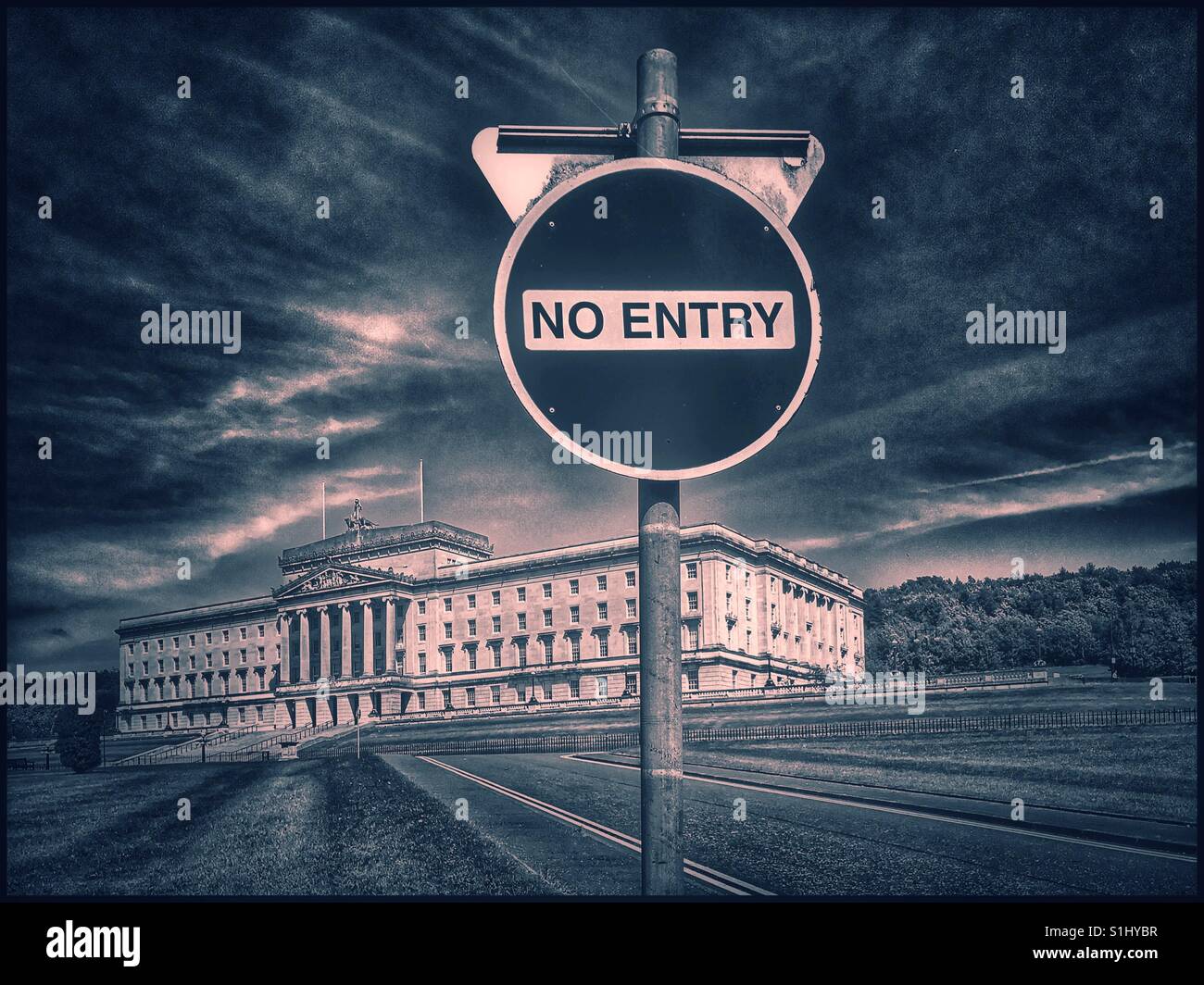 A No Entry sign by the side of an approach road in the Stormont Estate. In the background is the Stormont Parliament Buildings - home of the Northern Ireland Assembly. Photo Credit - © COLIN HOSKINS. Stock Photo