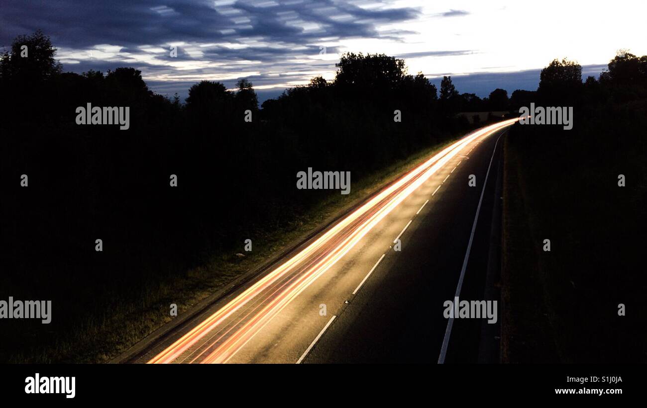 Car reverse red light trails on a UK left hand drive road Stock Photo
