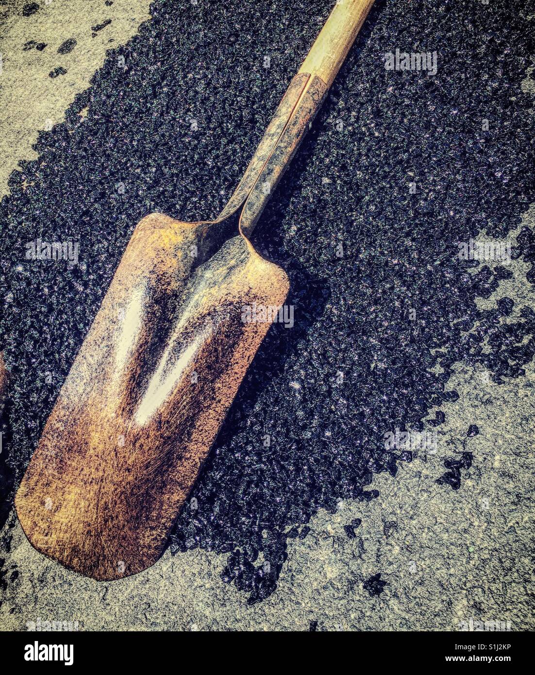 Shovel on top of freshly poured asphalt, city street, NYC, USA - Smartphone Captured Stock Image