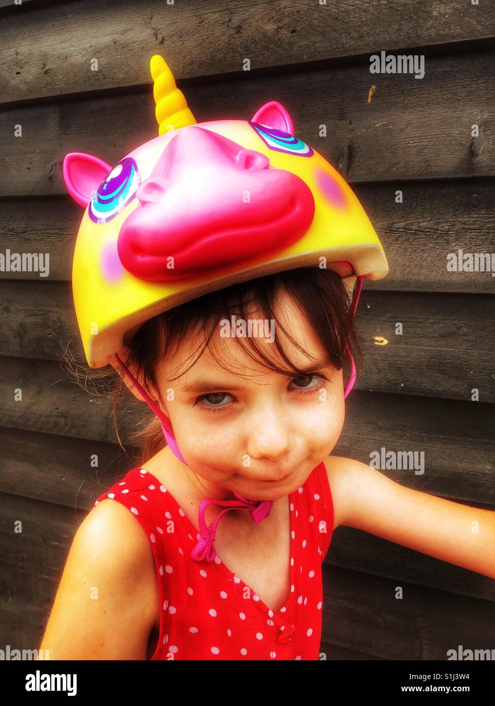 Girl wearing unicorn cycling helmet - Smartphone Captured Stock Image
