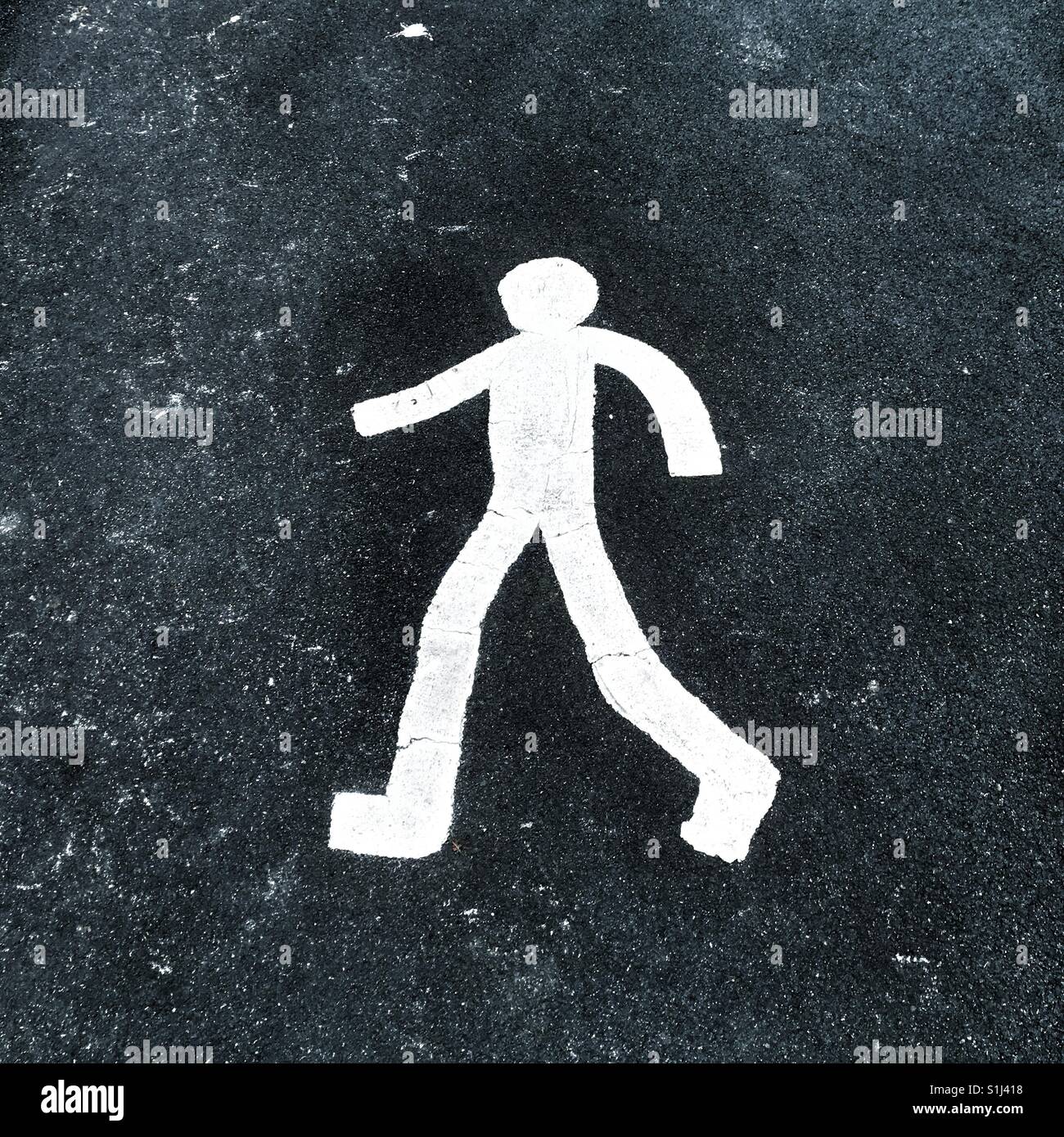 A white painted figure of a man walking on road indicating a pedestrian zone - Smartphone Captured Stock Image