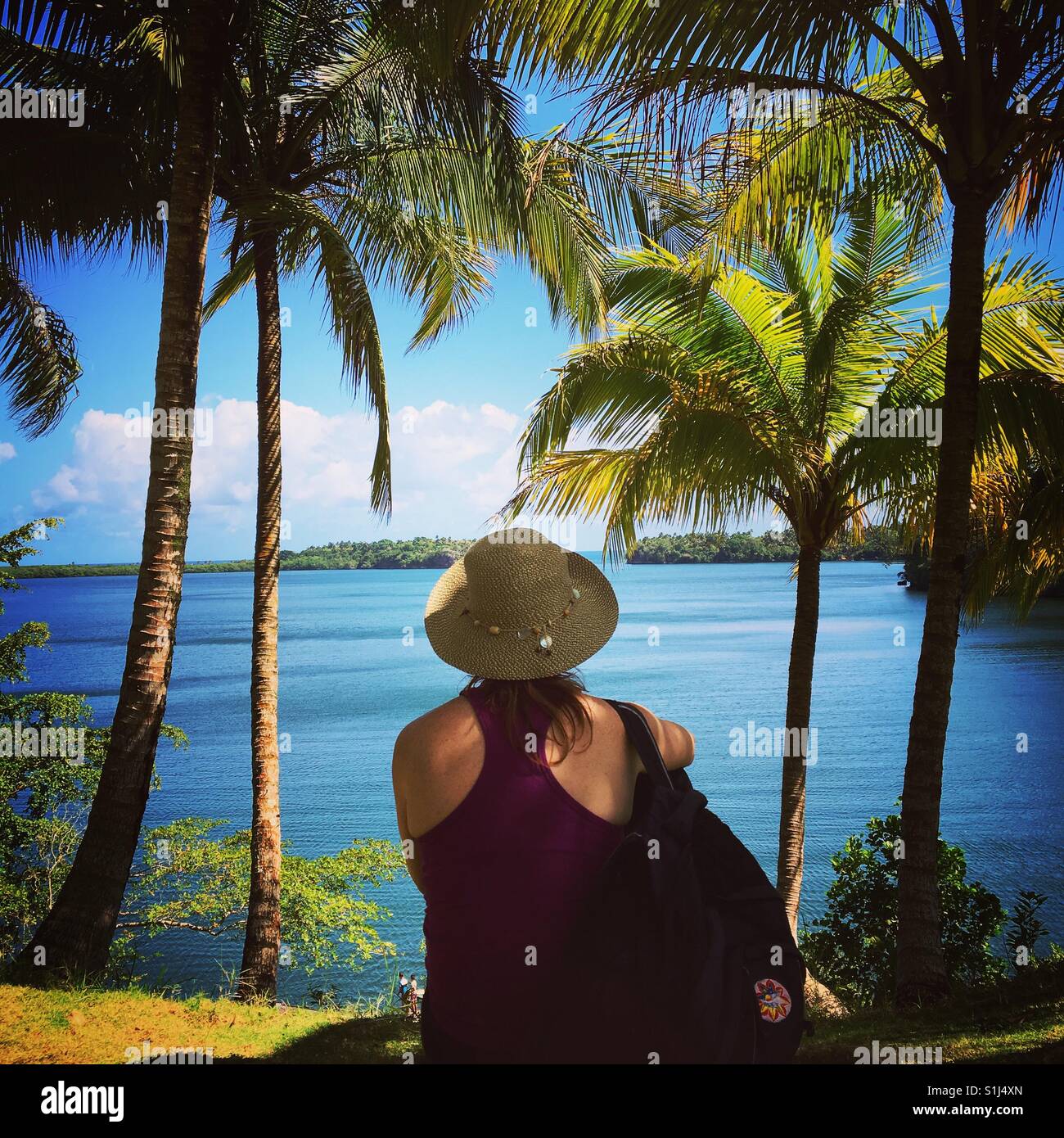Female tourist looking out at ocean on tropical island - Smartphone Captured Stock Image