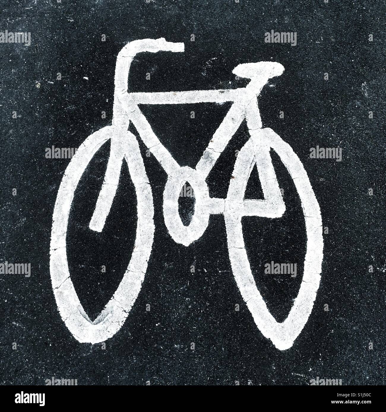A white painted image of bicycle on road indicating cycle lane - Smartphone Captured Stock Image